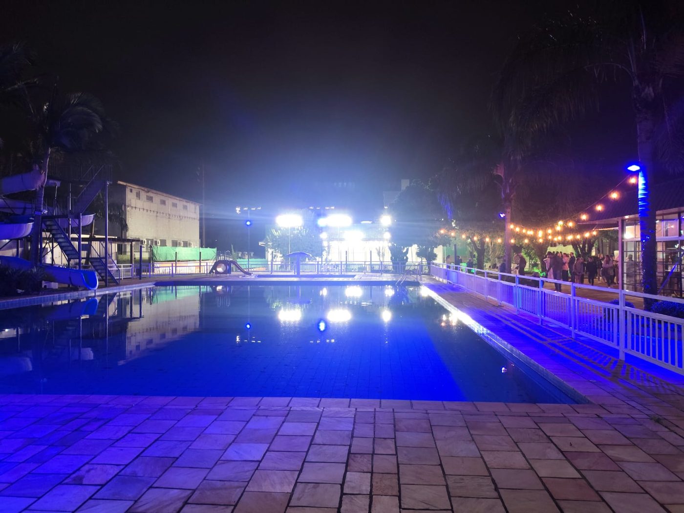Piscina e área externa com iluminação decorativa colorida