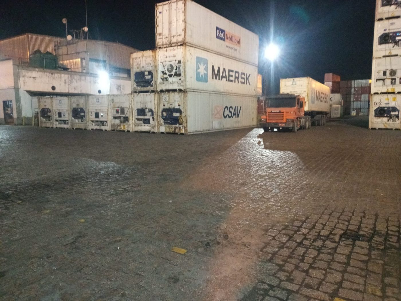 Terminal portuário com contêineres iluminados à noite